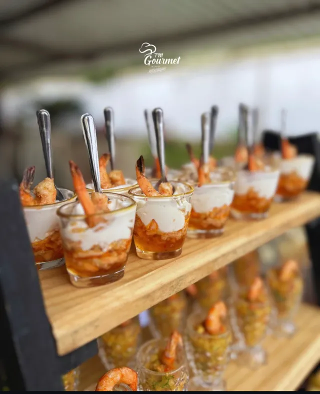 Verrines gourmet de camarão com molho especial servidas em copinhos individuais em expositor de madeira